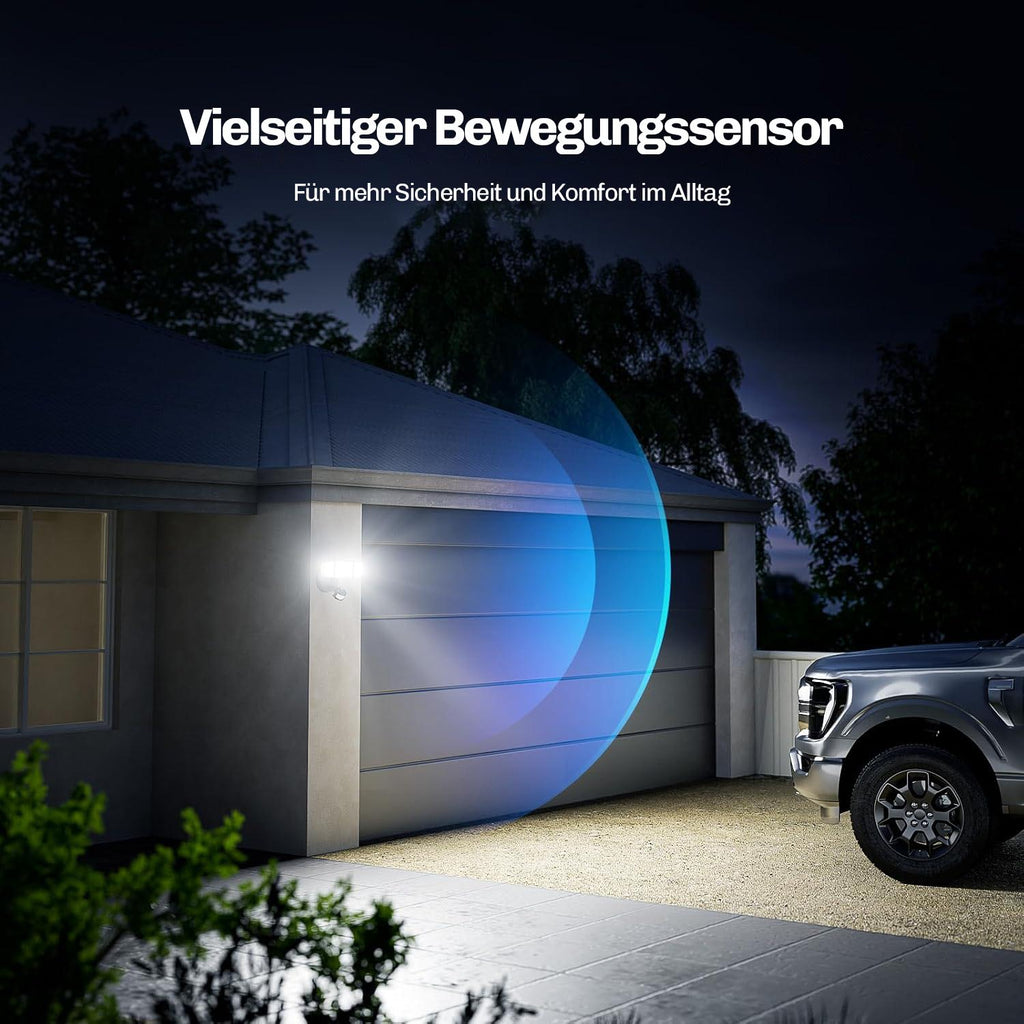 Montierter LED Sicherheitsstrahler an einer Garage, der Einfahrt und Fahrzeug bei Dunkelheit über den Bewegungssensor beleuchtet